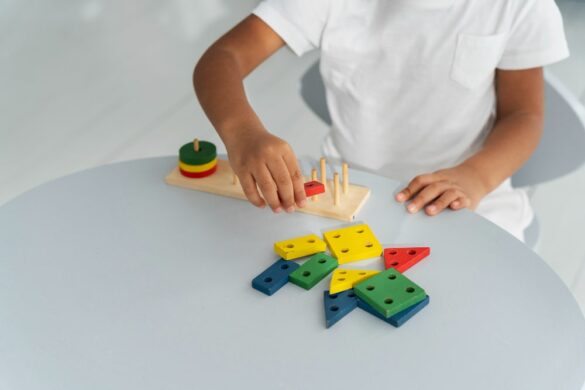 Enfant manipulant des jeux éducatifs Montessori colorés sur une table blanche