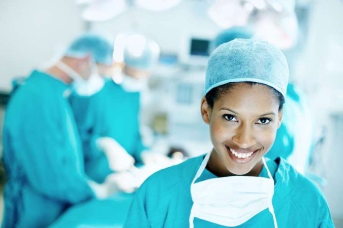 Une chirurgienne souriante en salle d'opération, illustrant une situation d'urgence vitale.